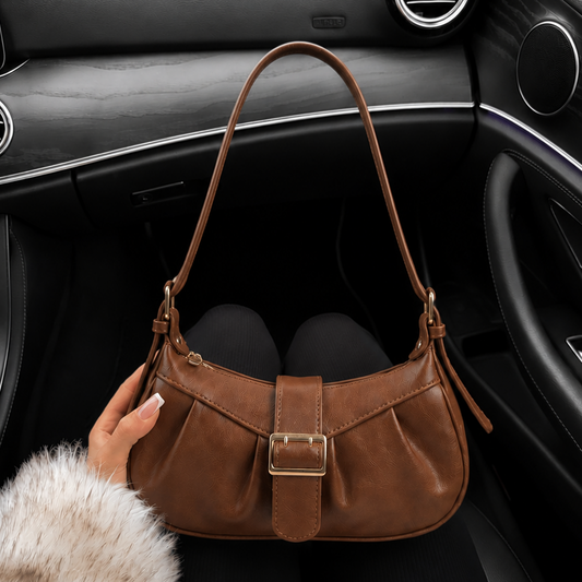 Brown leather handbag on a car seat with a fur coat in the foreground