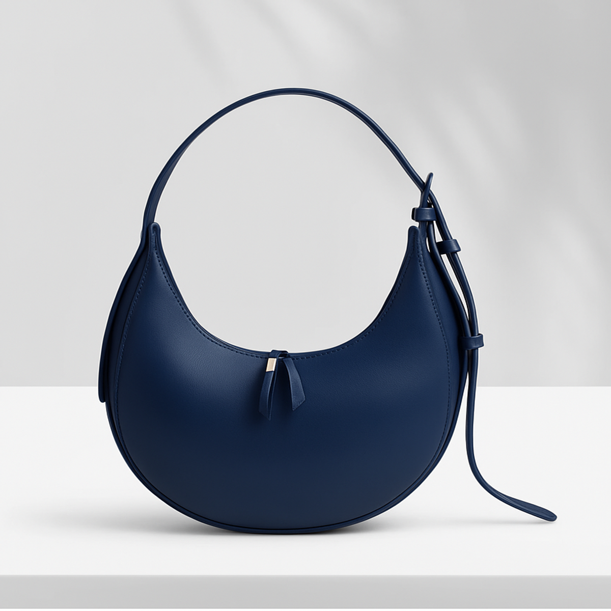 Sleek Lyana Claudia black hobo bag with U-shaped design, single zipper compartment, and adjustable shoulder strap.